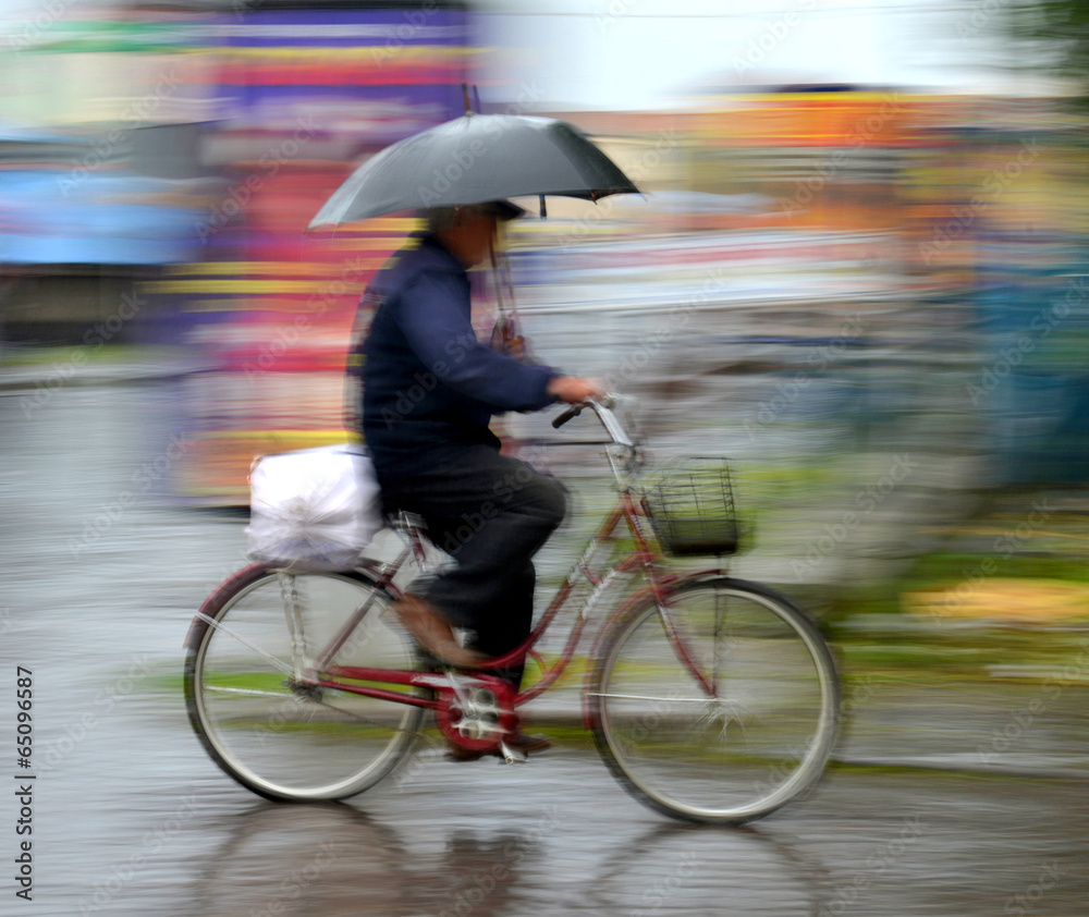 雨天骑自行车在街上行驶