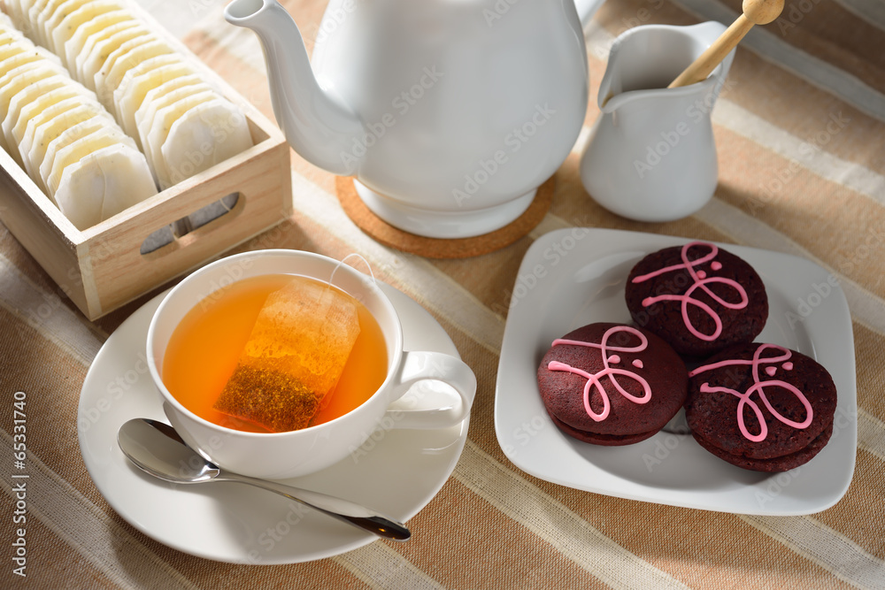 一杯茶，桌上有饼干和茶包