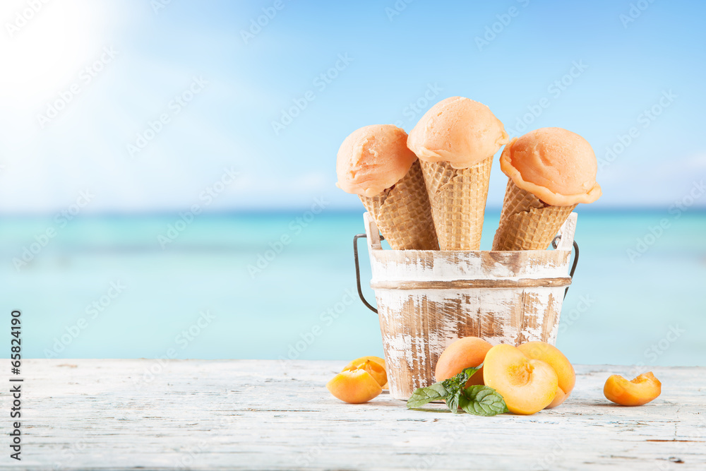 Apricot ice cream scoops in cones with blur beach