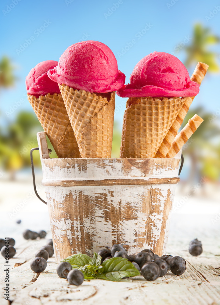 Ice cream scoops in cones with blur beach