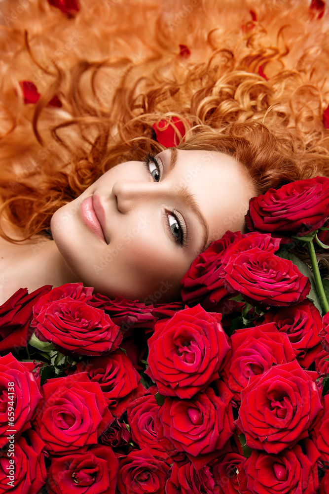 留着烫过的红头发和美丽的红玫瑰的女人