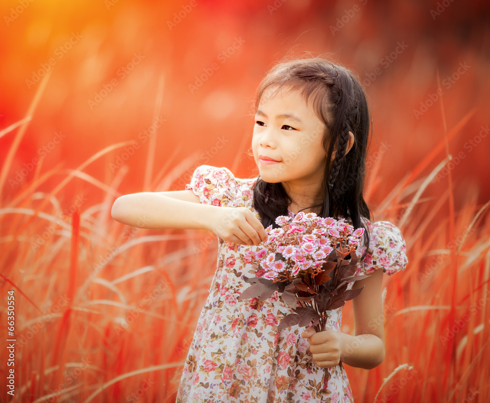 亚洲小女孩在草地上大笑