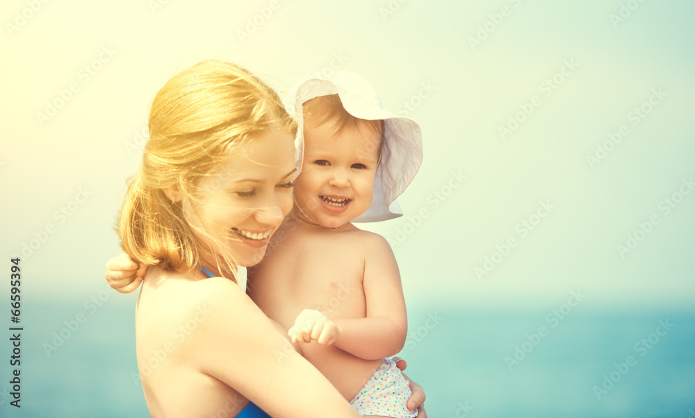 海滩上的幸福家庭。母亲和宝贝女儿