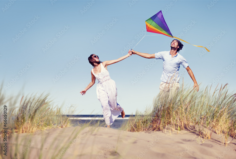 快乐的情侣在海边玩风筝