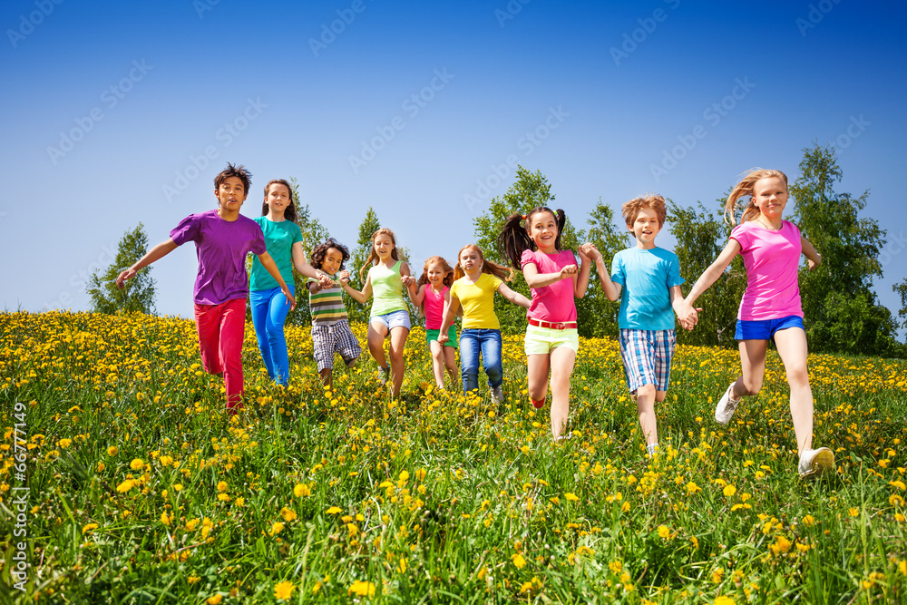 奔跑快乐的孩子们在绿茵场牵手