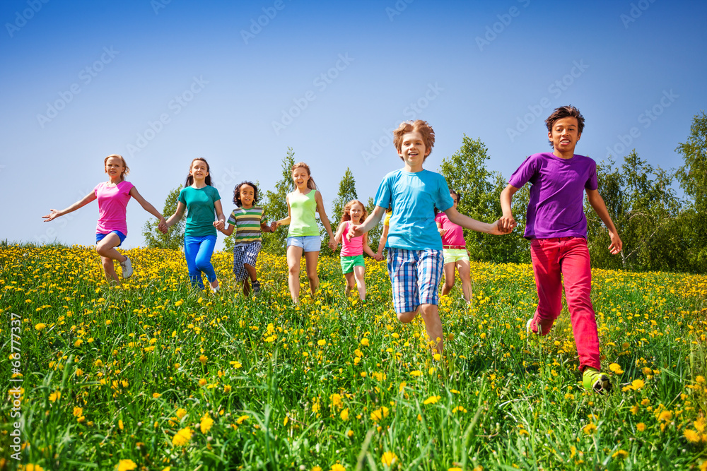 奔跑的孩子们在绿色的草地上牵着手