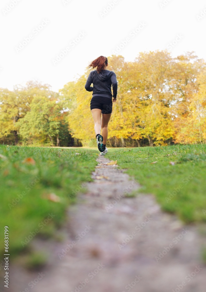 健康的女运动员在公园跑步