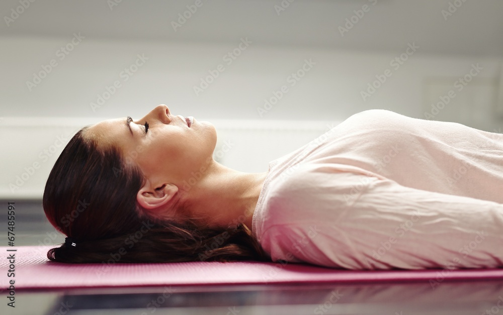 躺在瑜伽垫上放松肌肉的女人