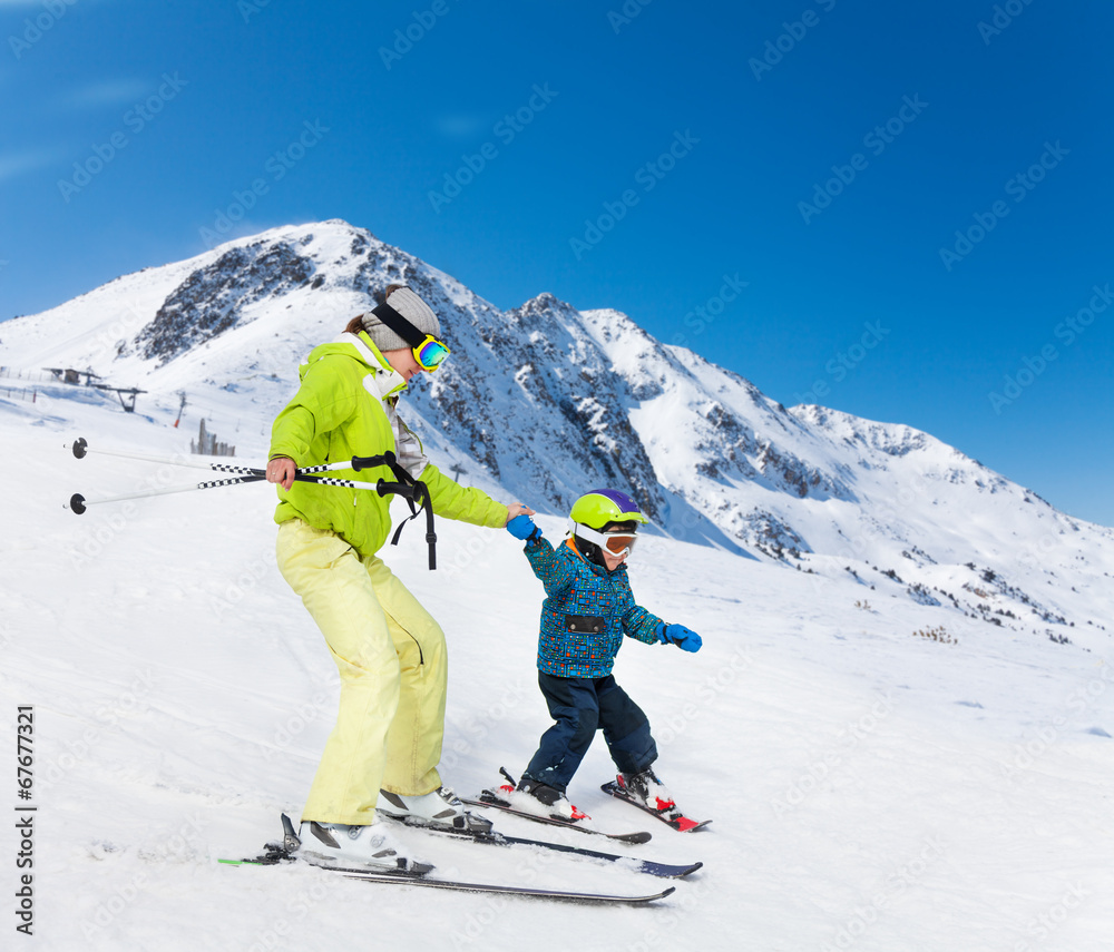 教练和孩子滑雪下山