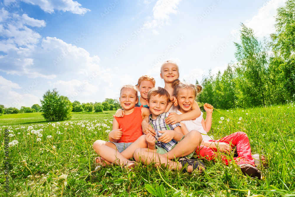 五个孩子一起坐在草地上