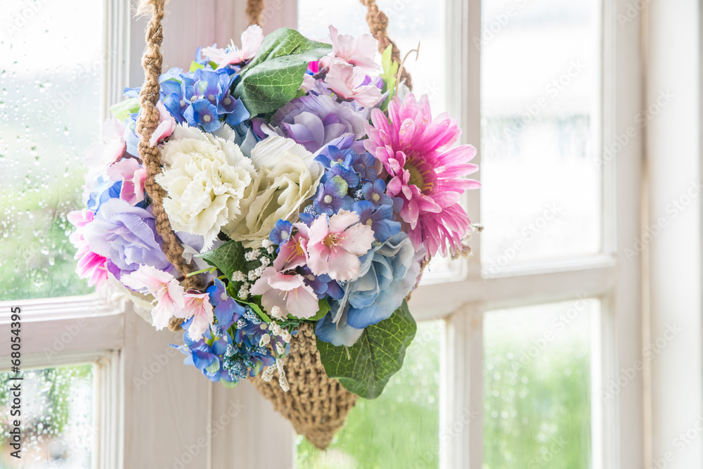 Basket of flower hanging on window