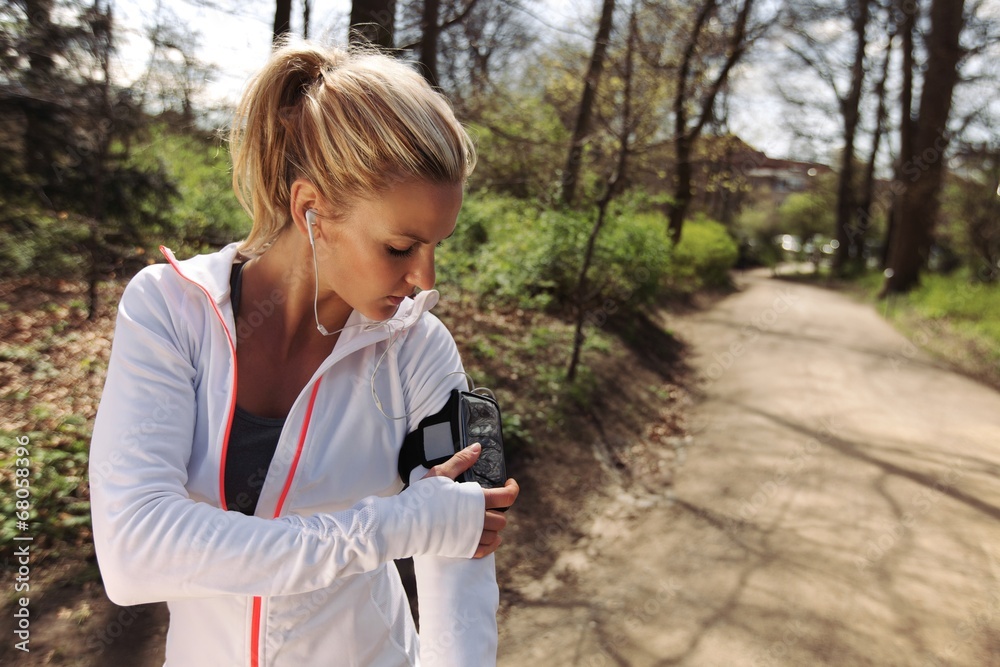 女性跑步者在智能手机上监控自己的进度