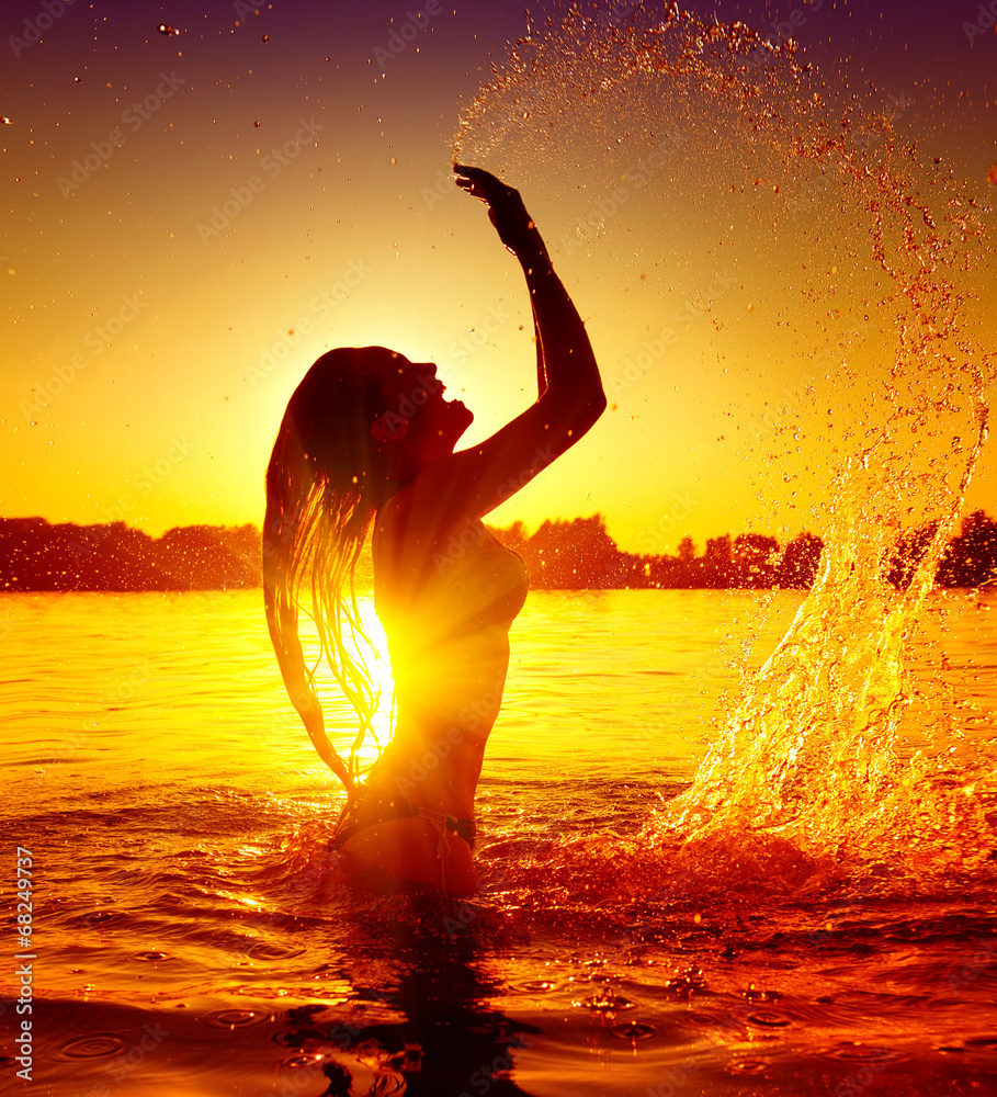 日落时分，一个十几岁的女孩在夏日海滩上游泳戏水