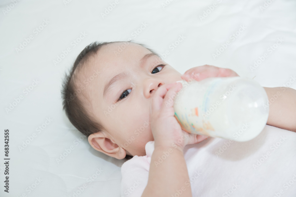 亚洲漂亮女婴在床上喝牛奶