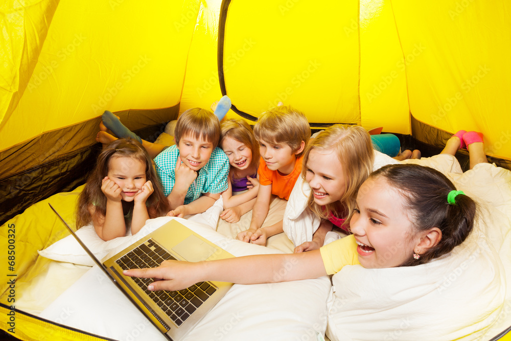 许多孩子在帐篷里和笔记本电脑一起大笑