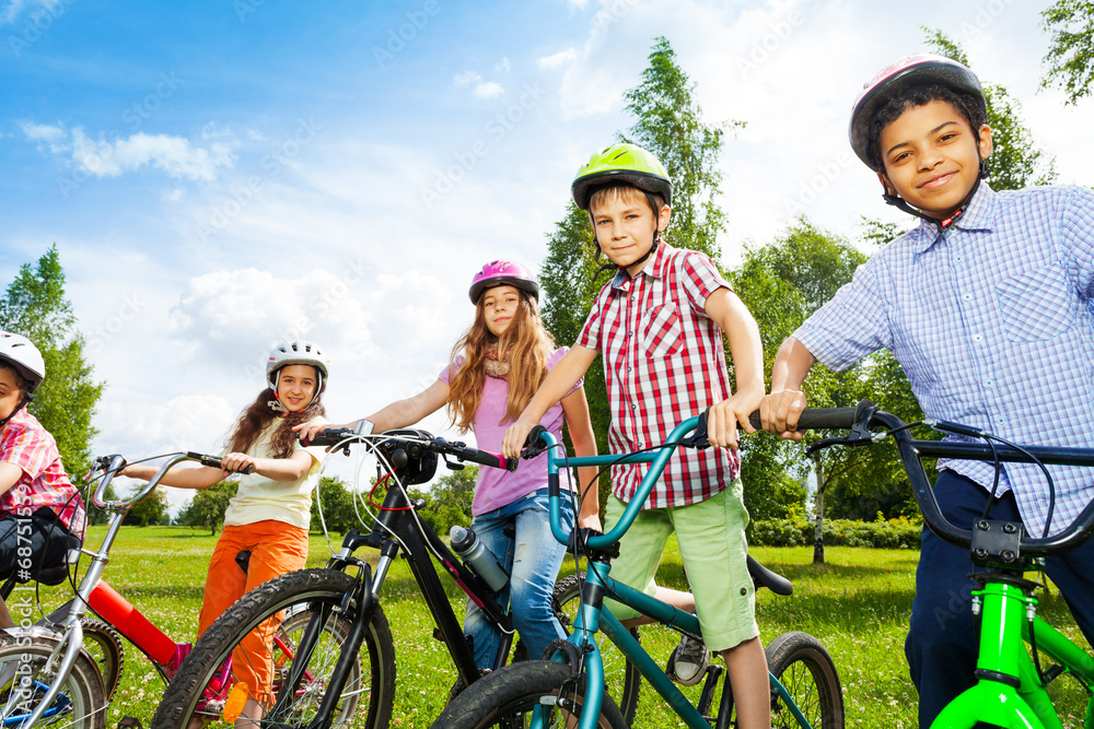 一排快乐的孩子戴着五颜六色的自行车头盔