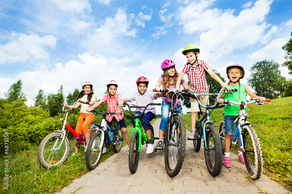 快乐的孩子们排成一排戴着五颜六色的自行车头盔