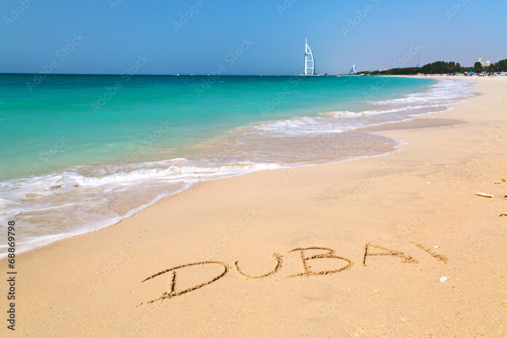 碧绿海水海滩上的迪拜标志