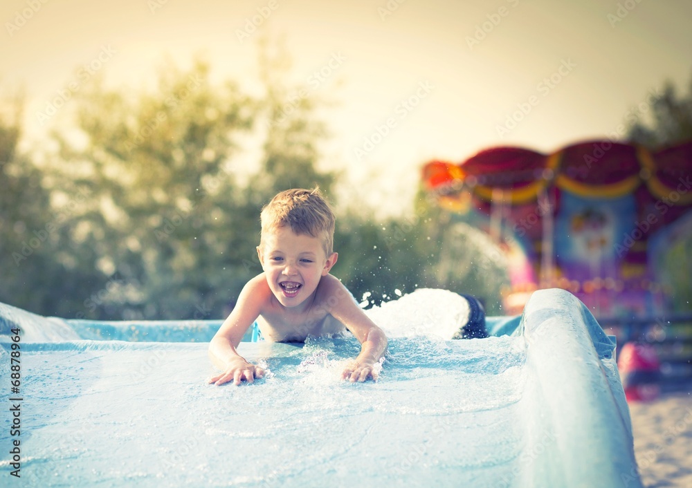 孩子在水上乐园的水滑梯上，暑假