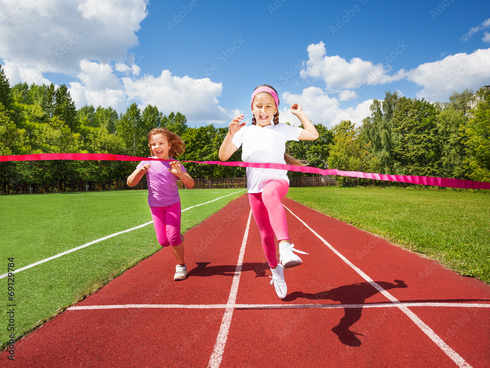 女孩奔跑着，激动地走向缎带，赢得比赛