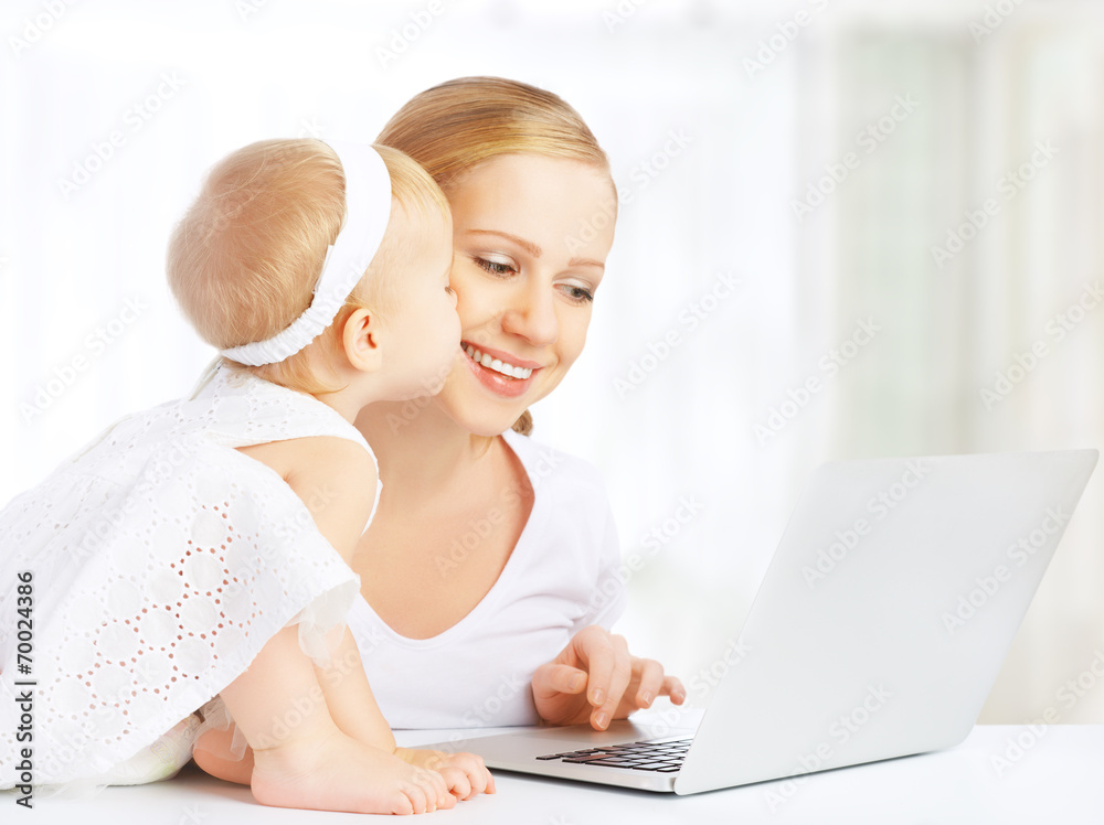 母亲和婴儿在家使用笔记本电脑