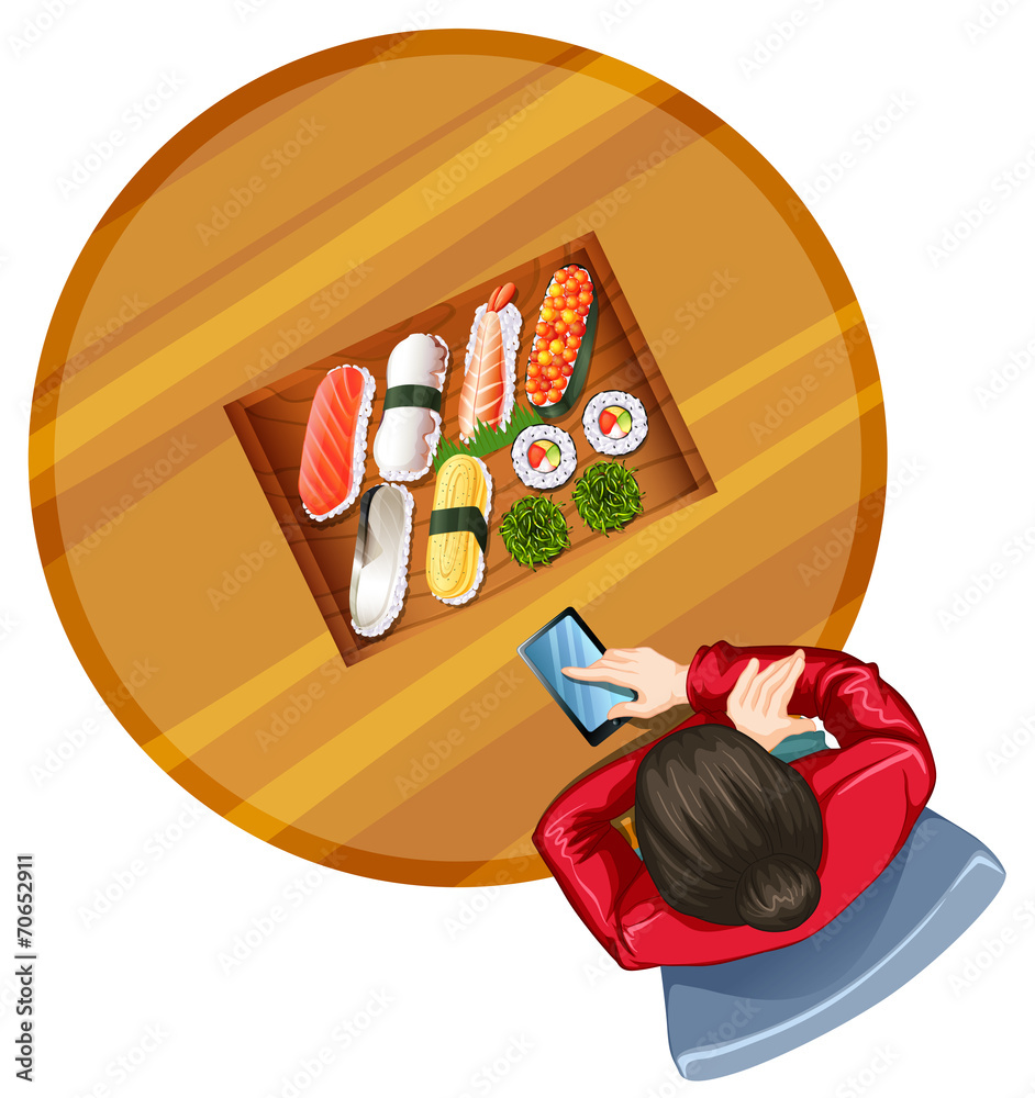 一个女孩在餐桌上吃寿司的俯视图