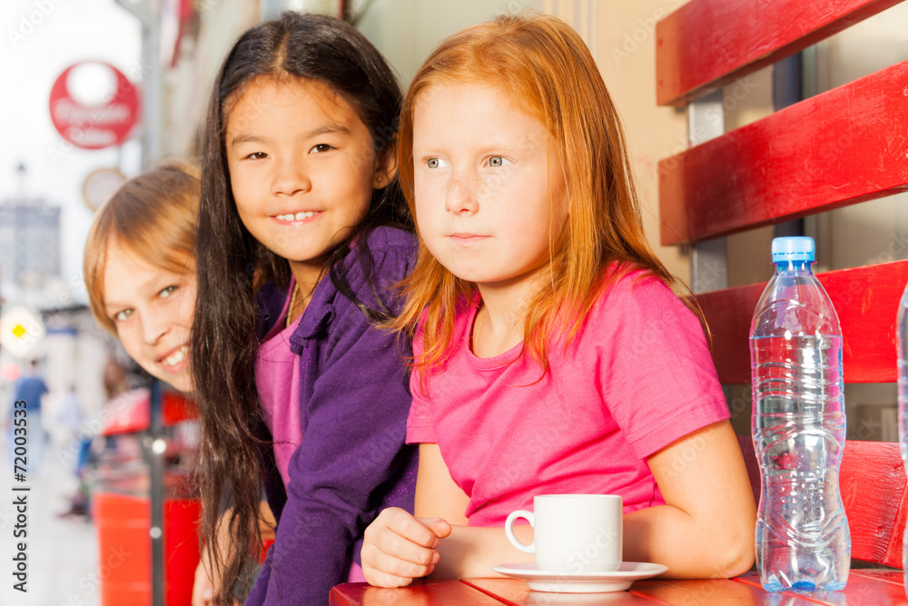 一群国际孩子坐在外面的咖啡馆里