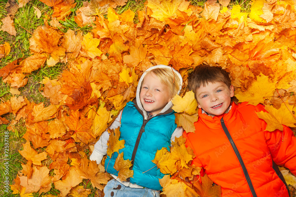 两个男孩躺在秋叶上俯视