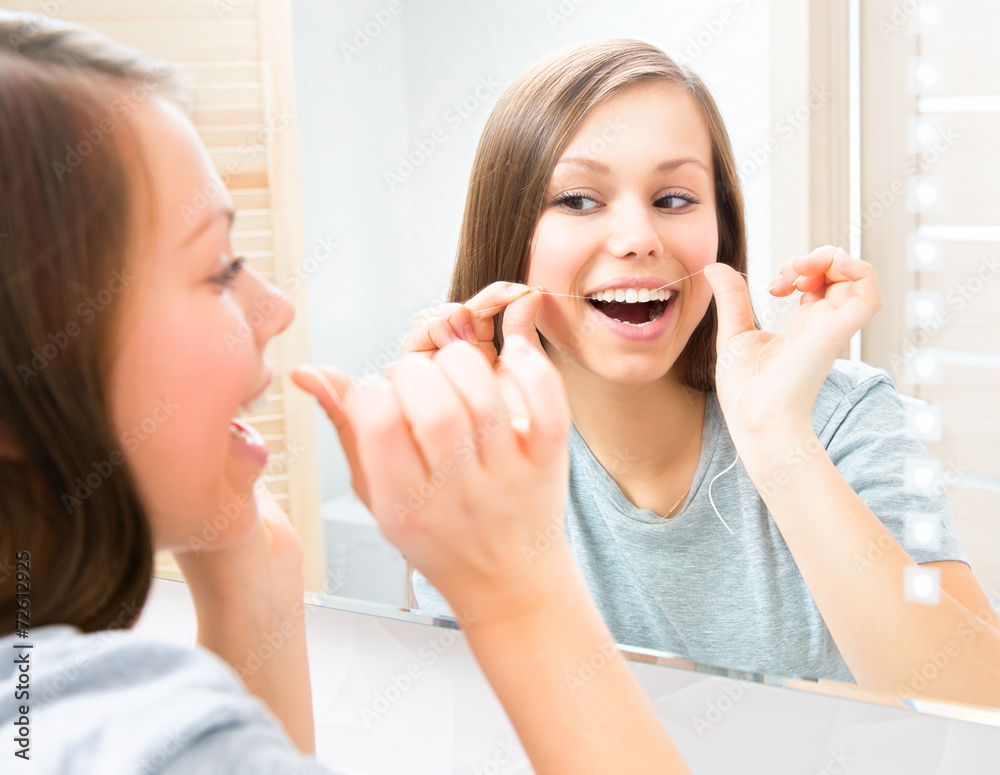 美丽的少女在家用牙线洁牙。牙齿卫生