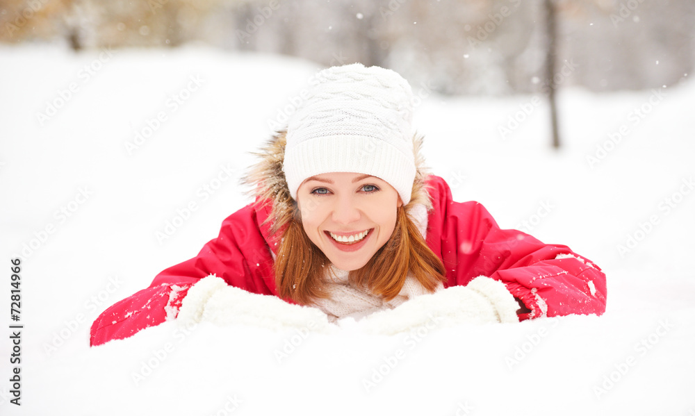快乐的女孩在户外冬天躺在雪地上大笑