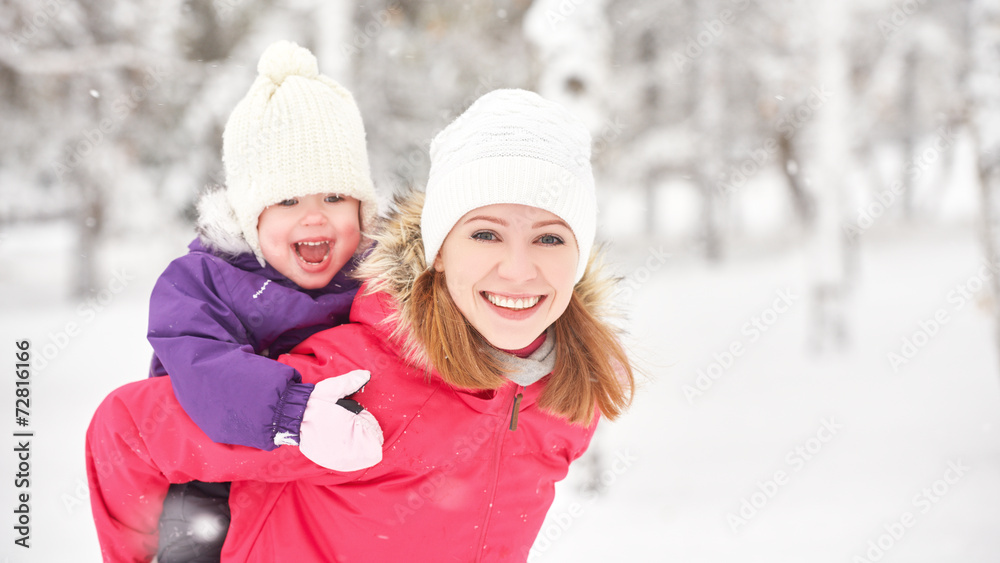 happy family mother and baby girl daughter playing  in winter