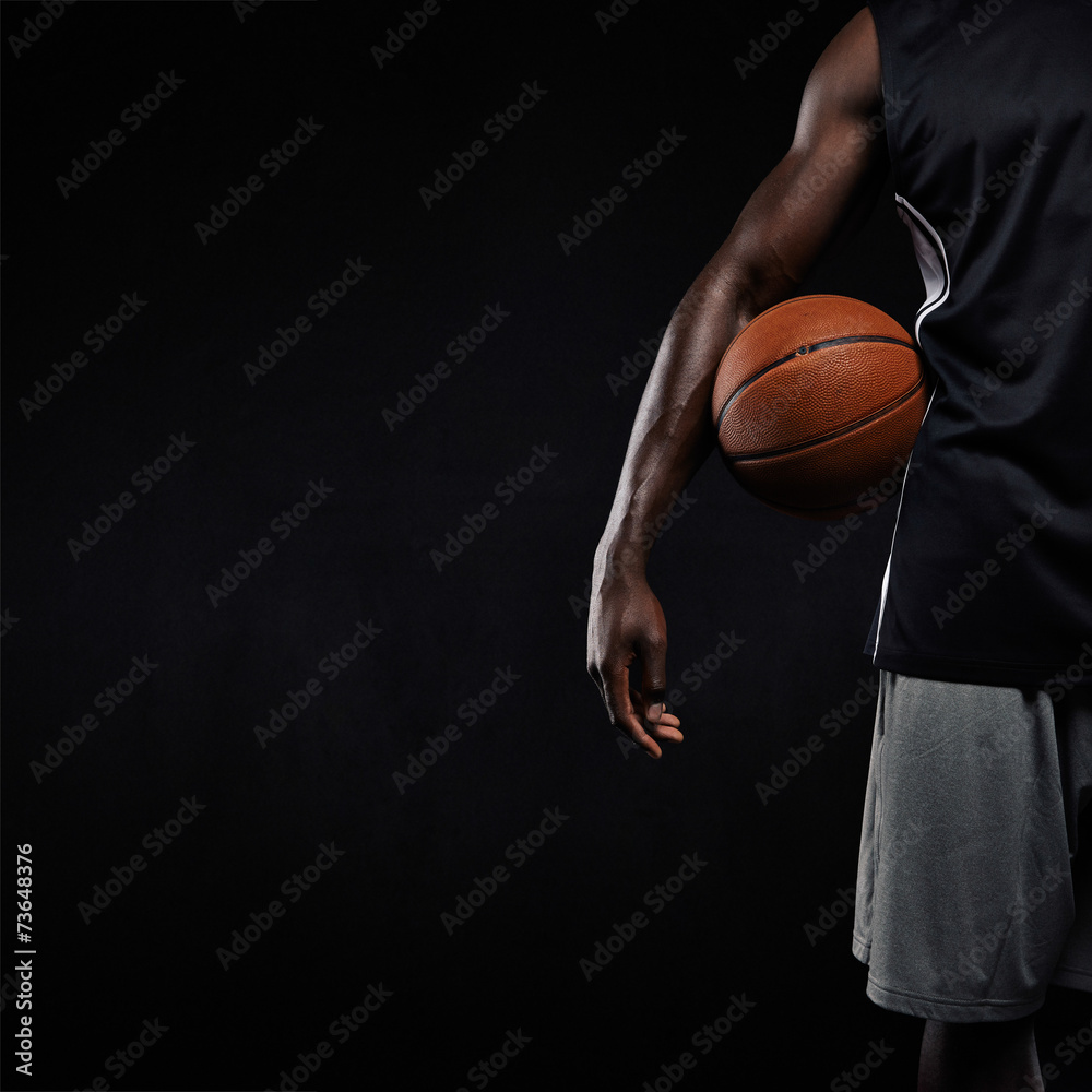 黑人篮球运动员拿着篮球站着