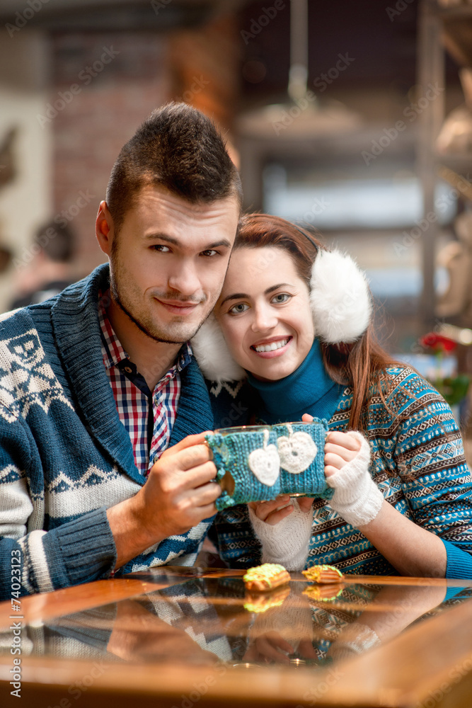 年轻夫妇在冬天的咖啡馆喝咖啡