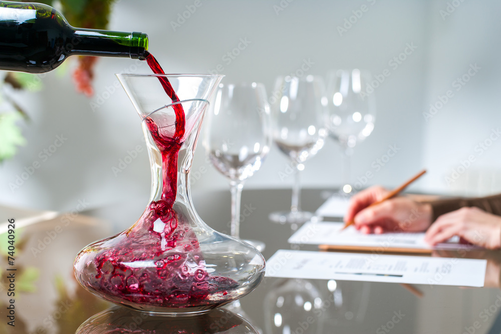 侍酒师将葡萄酒倒入滗析器。