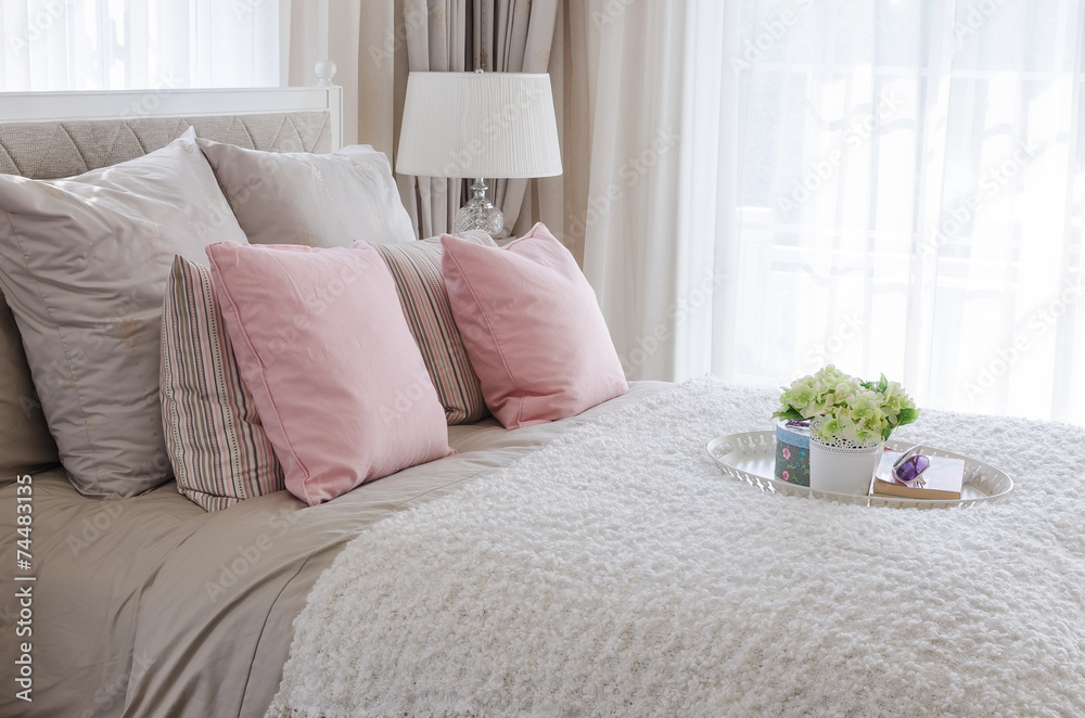 床上的粉色枕头配白色花盘