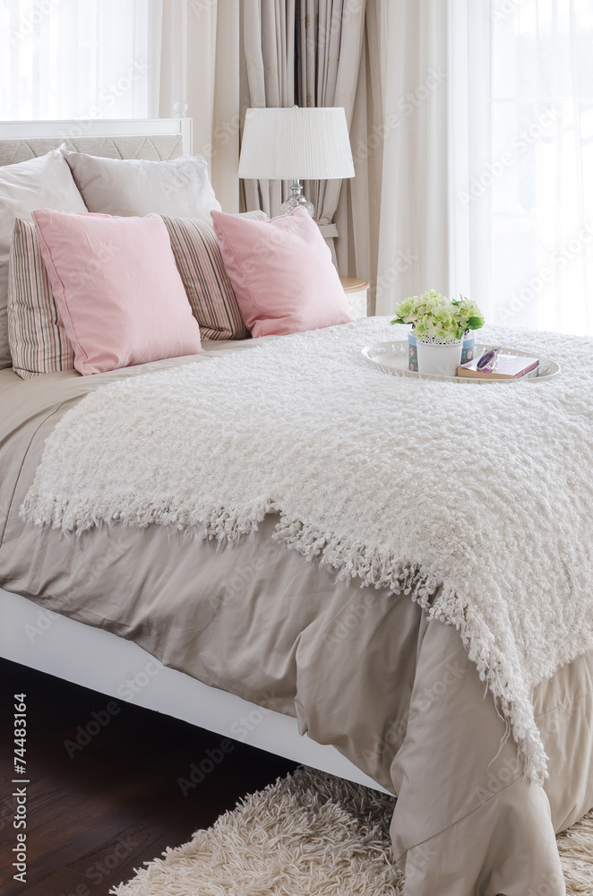 家里有白色花盘的床上粉色枕头