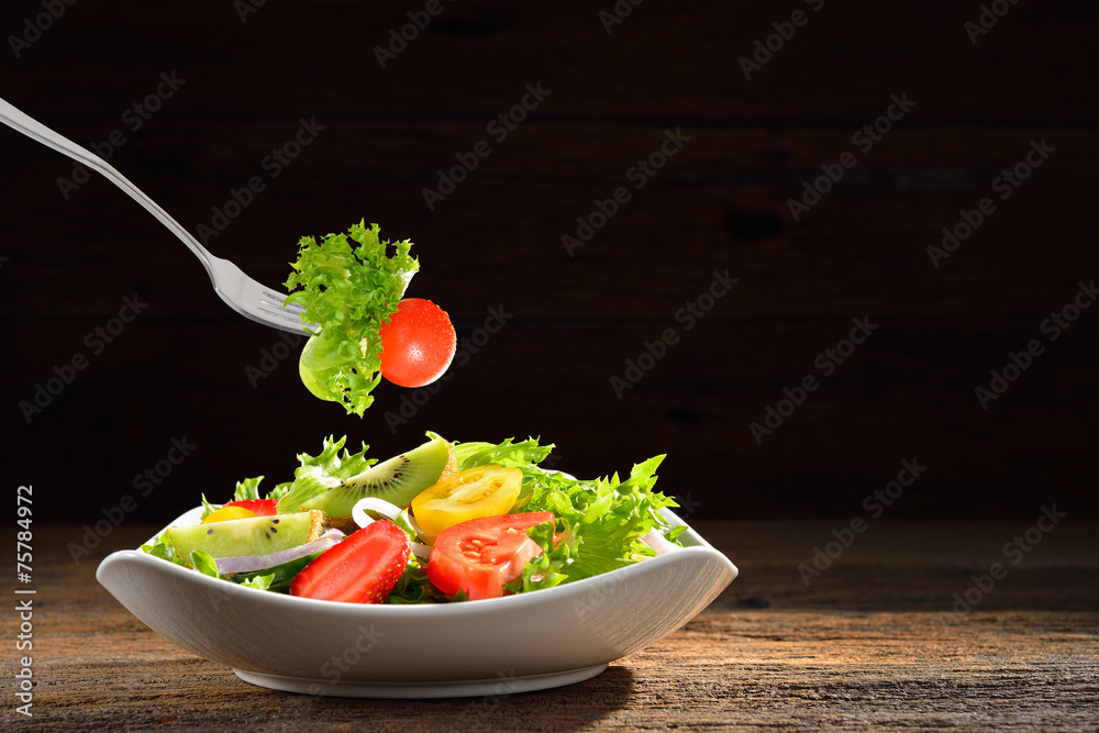 木制背景的碗里的水果和蔬菜沙拉