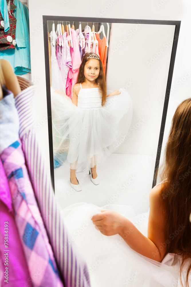 美丽的小女孩在镜子前尝试着装