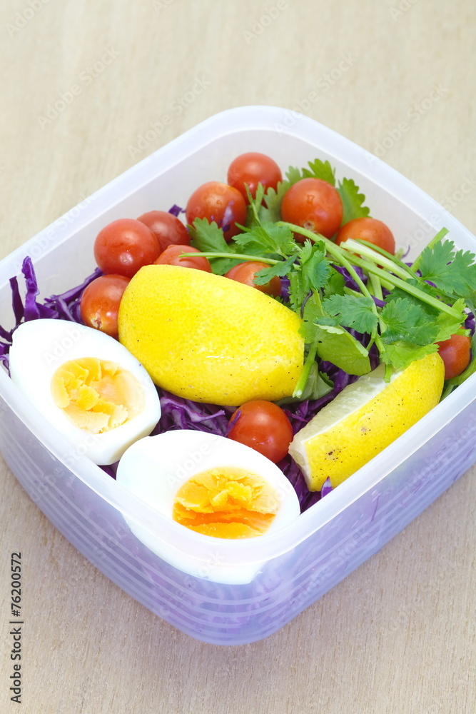 在塑料饭盒中混合蔬菜沙拉和煮鸡蛋