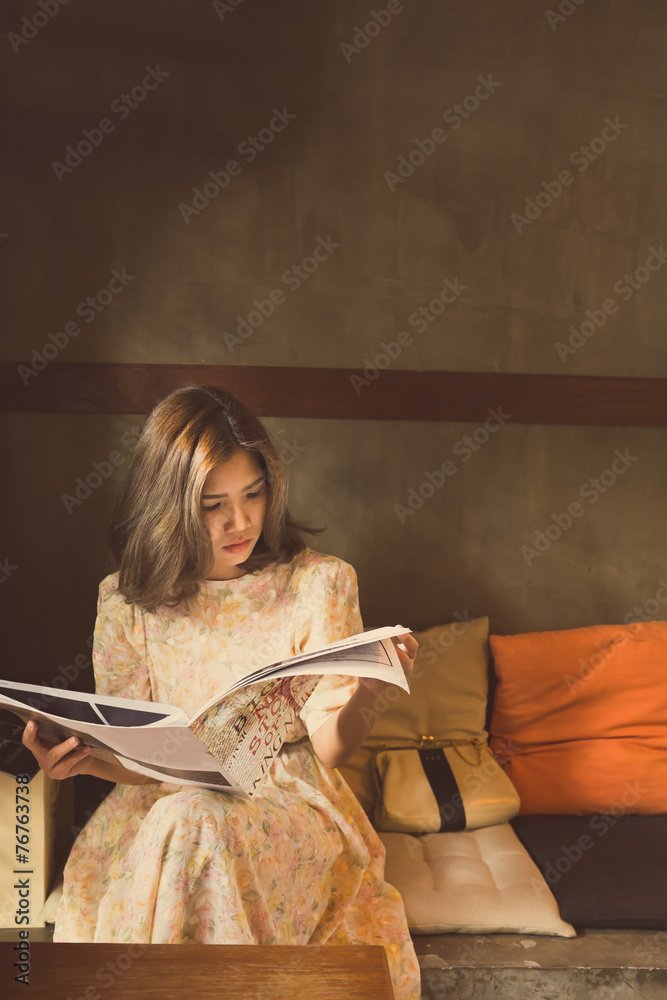 美丽的女人在温暖舒适的角落里阅读杂志，复古st