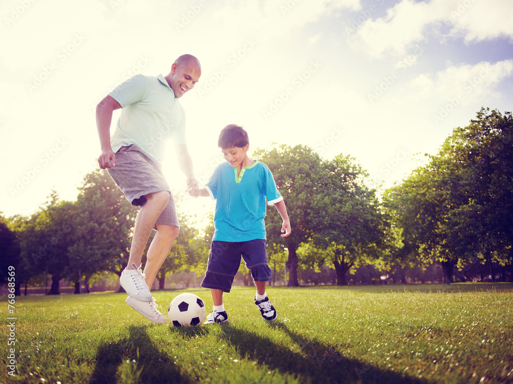 家庭父子踢足球夏季概念