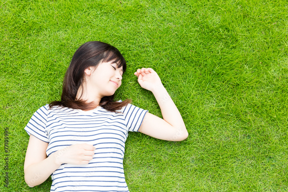 躺在草坪上的年轻亚洲女人