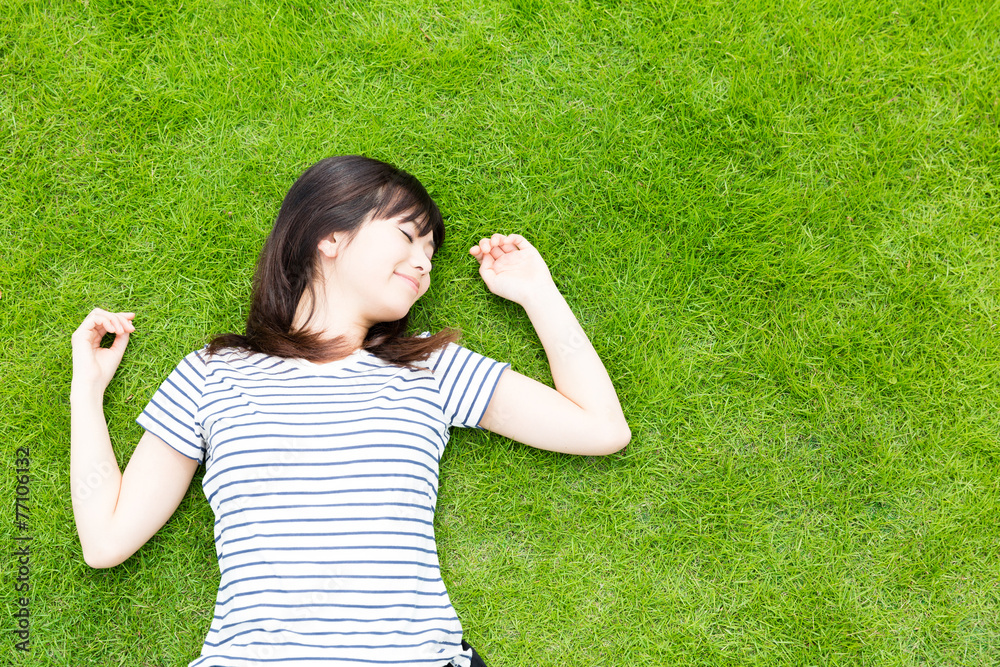 躺在草坪上的年轻亚洲女人