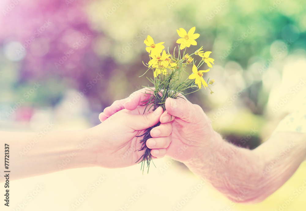 老人和年轻妇女在外面手捧鲜花