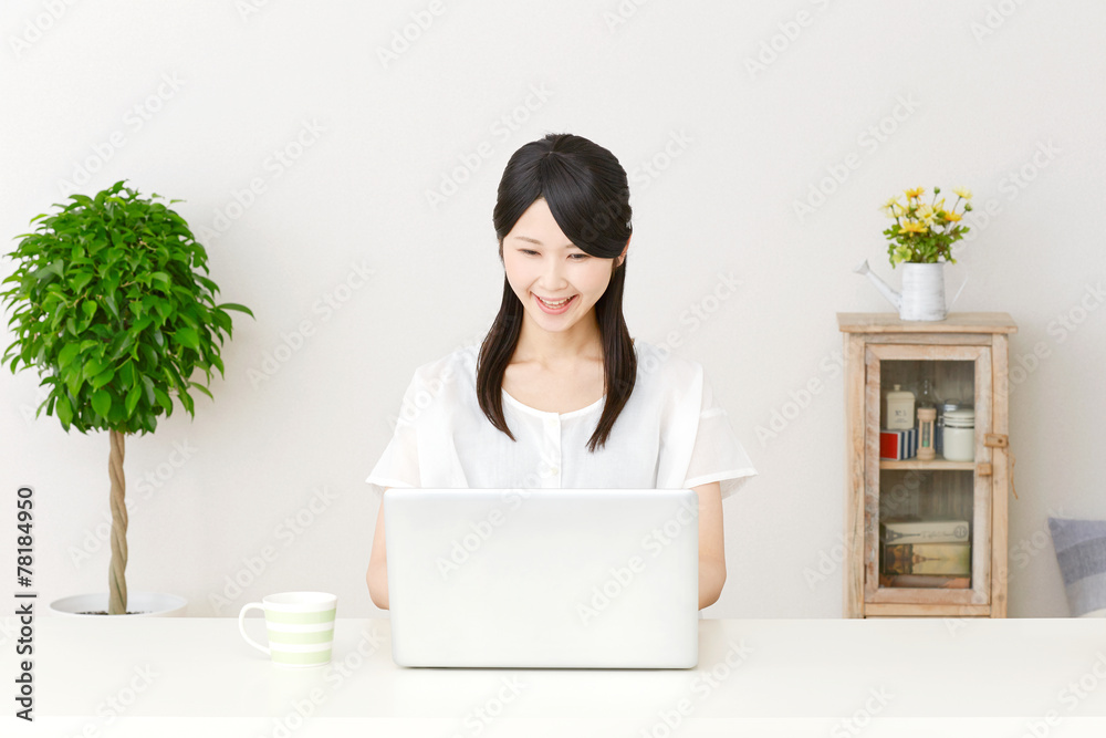パソコンの前で笑う女性
