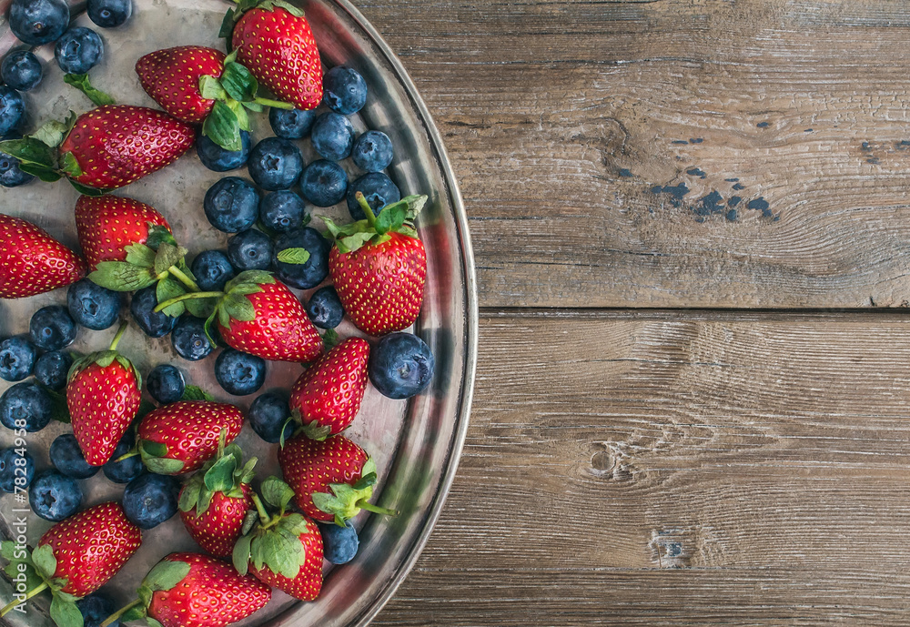 新鲜草莓和蓝莓混合物放在金属盘（托盘）上
1807356734,粗糙的木头背景上的一盘新鲜成熟多汁的柑橘