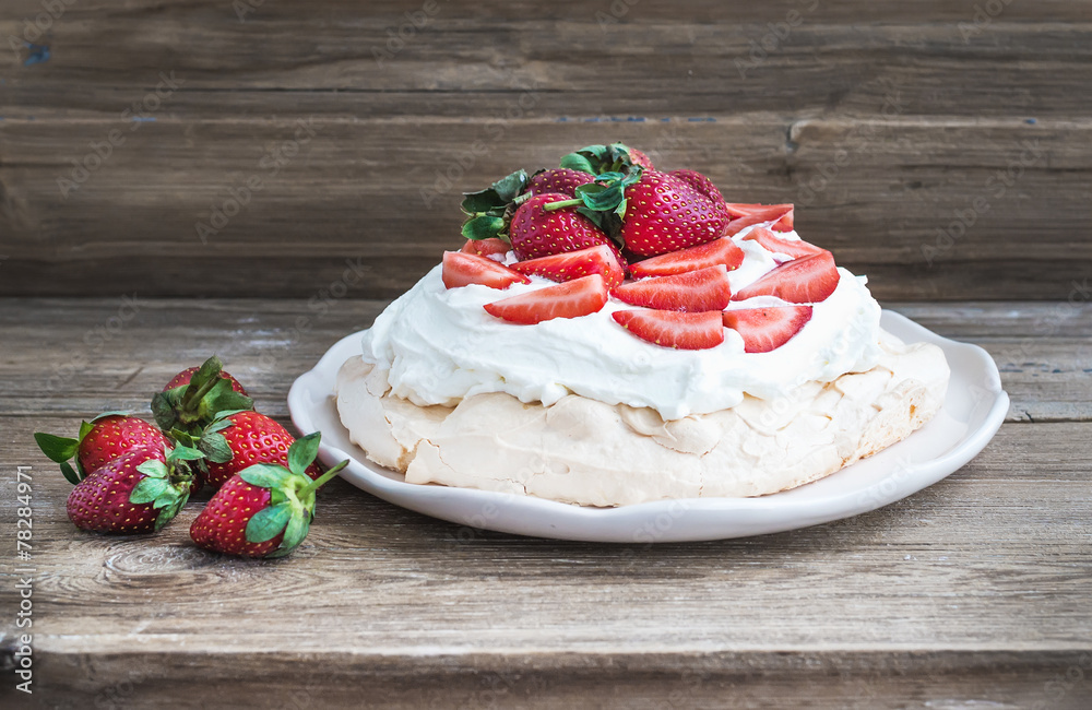 Rustic Pavlova cake with fresh strawberries and whipped cream ov