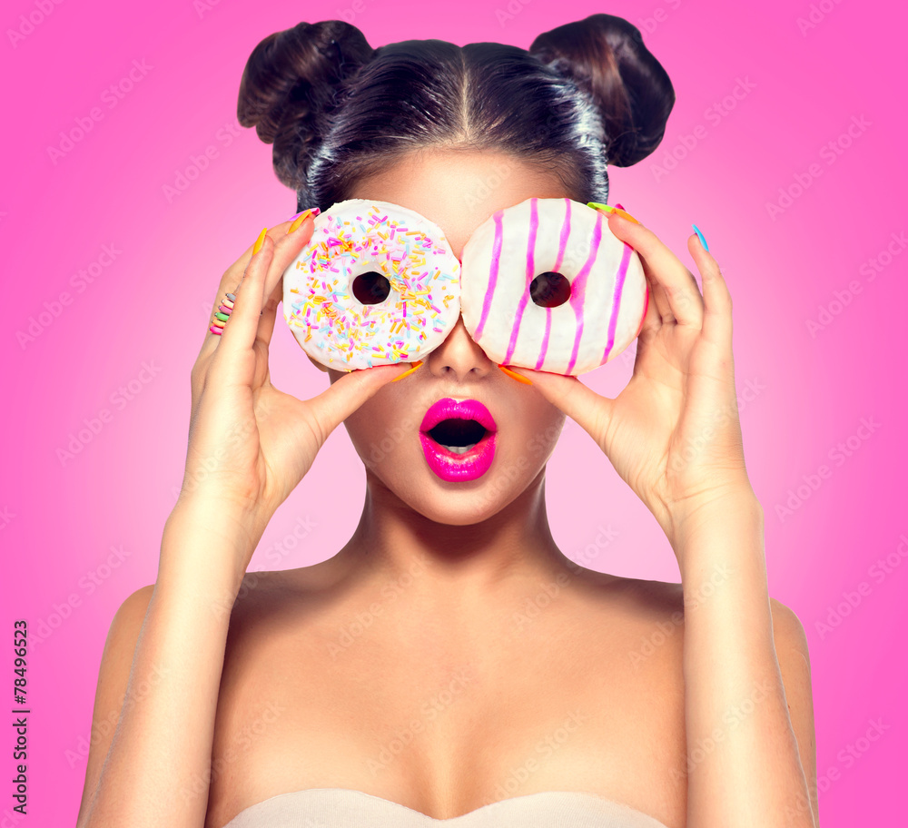 美女模特女孩吃五颜六色的甜甜圈。节食概念