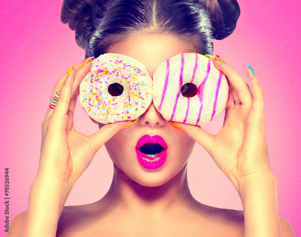 美女模特女孩吃五颜六色的甜甜圈。节食概念