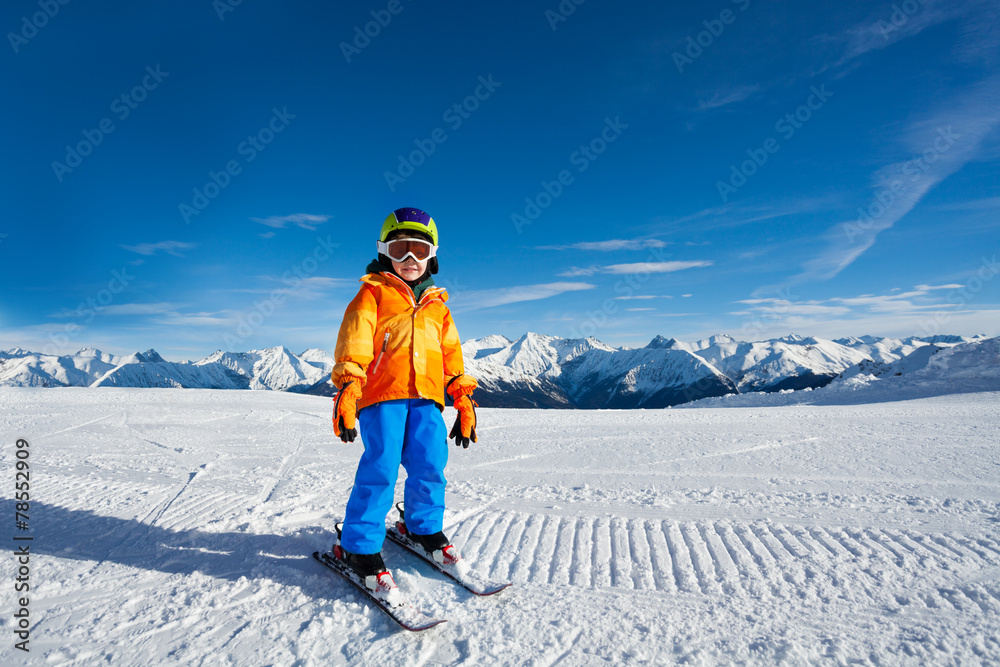 小男孩戴着滑雪面罩站在滑雪道上